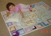 Miranda playing on meemaw's quilt
